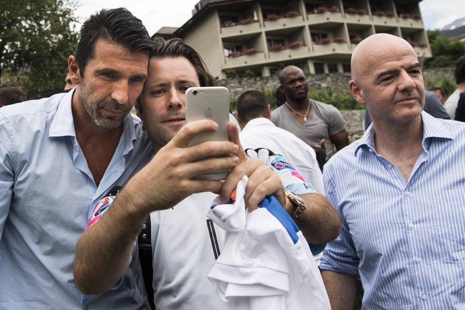 Un fan si scatta un selfie con Buffon. A destra spunta Gianni Infantino. Epa